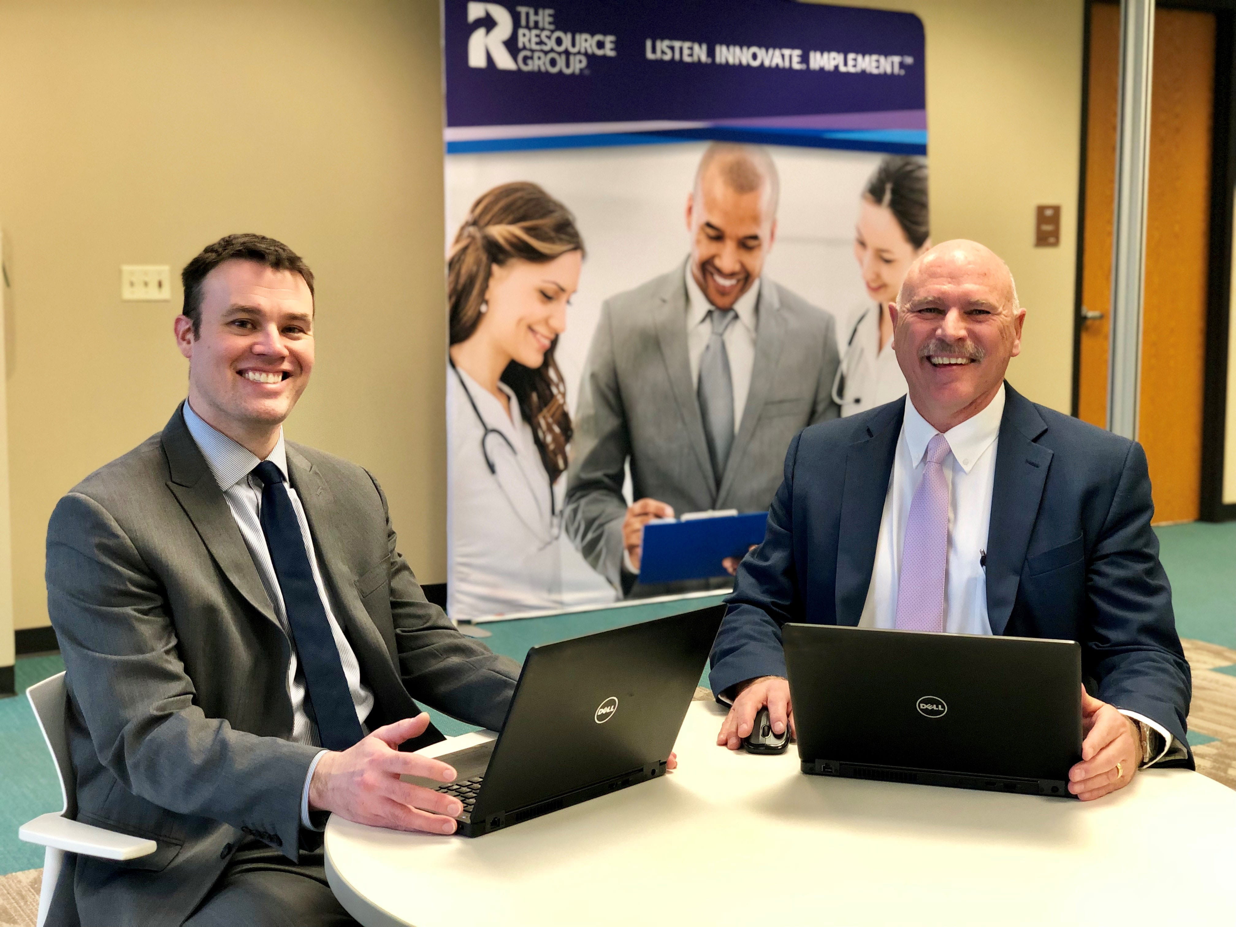 two businessmen at a table smiling