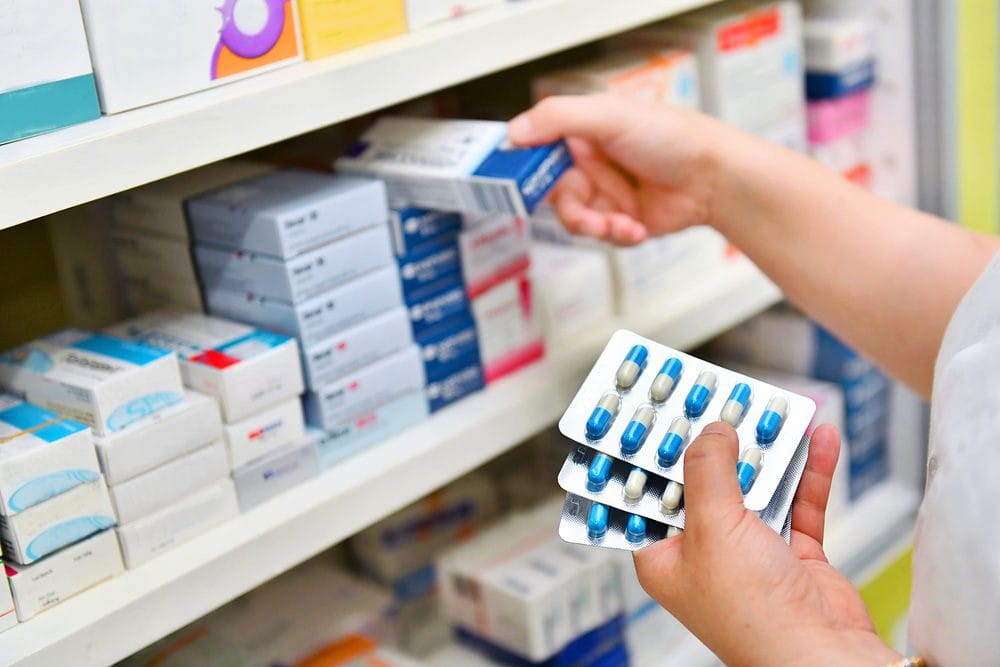 pharmacist takes medicine from shelf